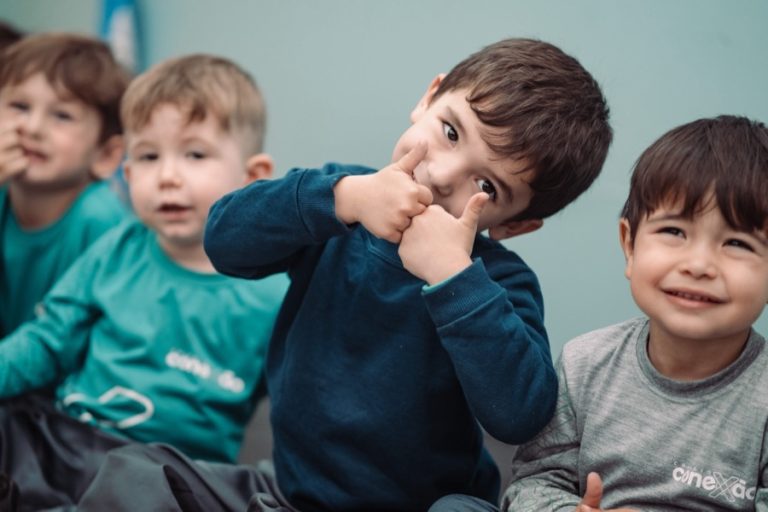 Alunos da Educação Infantil fazendo joinha durante atividade em sala