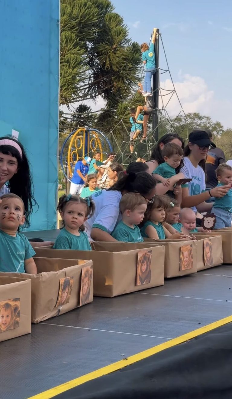 Alunos sentados no palco durante o Conexão Família
