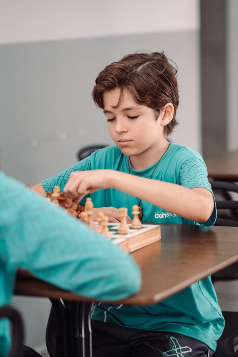 Aluno jogando xadrez em atividade do Colégio Conexão