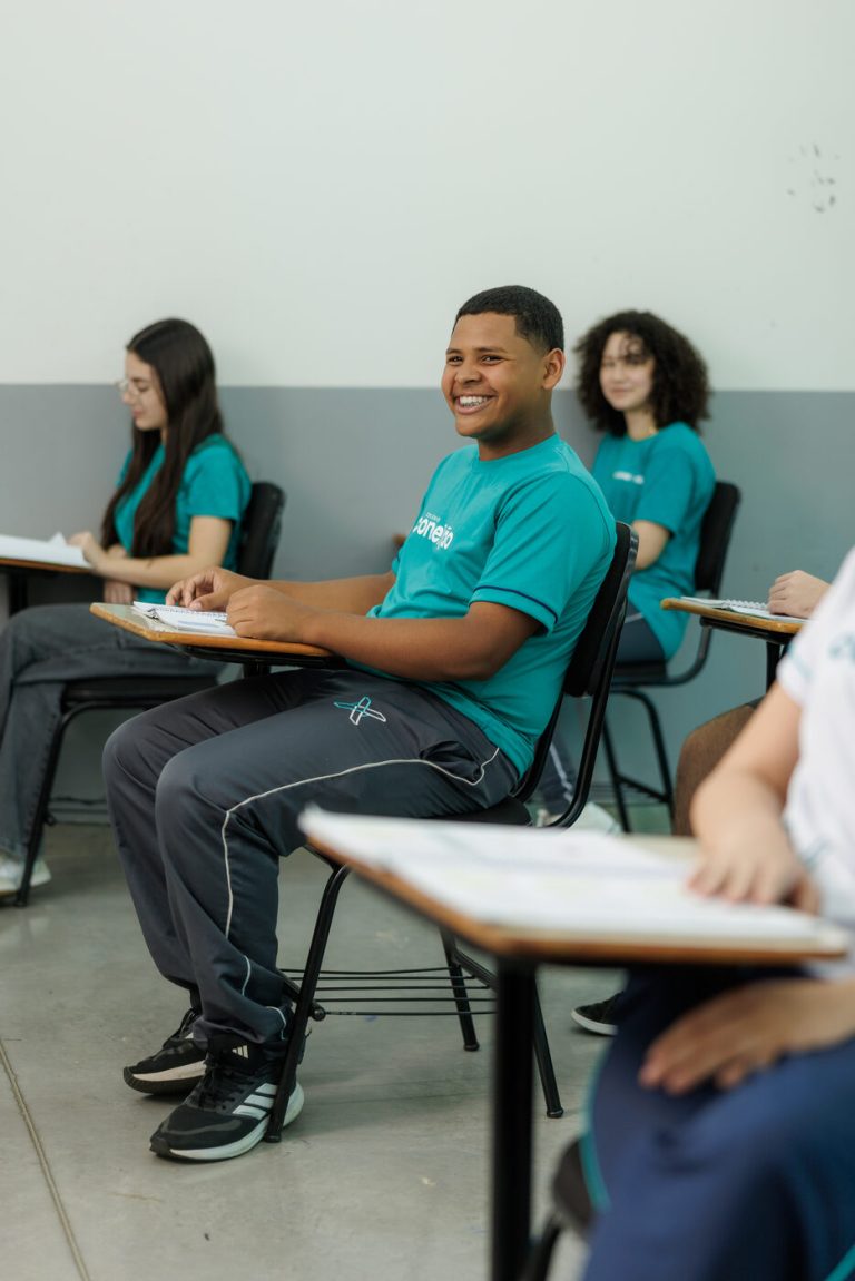 Aluno do Ensino Médio sorrindo em sala de aula